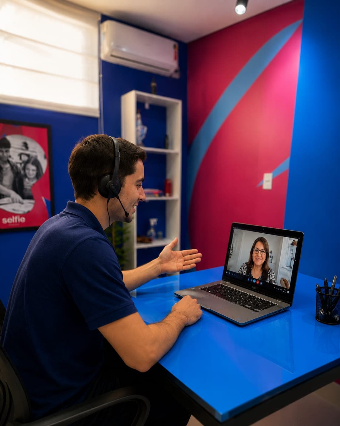 Profissional com headset em sessão por vídeo, conversando com a professora pela tela do notebook.